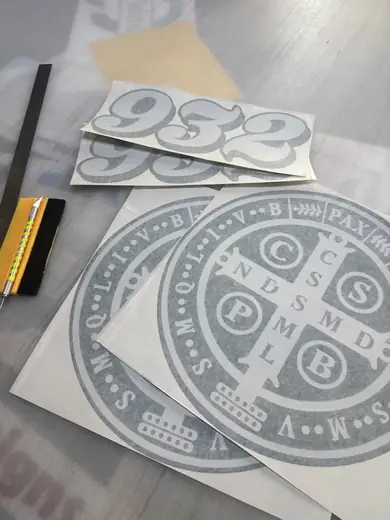 Cut vinyl decals being weeded on a work table