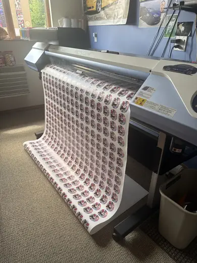 Freshly printed vinyl feeding off a wide-format printer