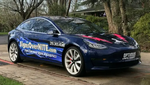 Blue Tesla with Signs OverNITE wrap graphics