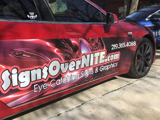 Red car wrapped with Signs OverNITE graphics